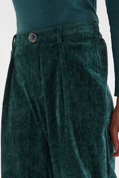Dark green velvet trousers with a jewel button