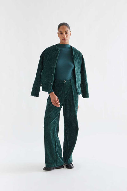 Dark green velvet trousers with a jewel button