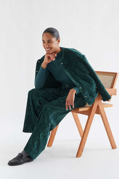 Dark green velvet trousers with a jewel button